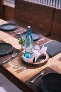 a table with plates and a bottle on top of it at Bell Mount Mussoorie Hill view Hotel in Mussoorie