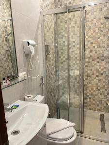 a bathroom with a shower and a toilet and a sink at Downtown Hotel in Tbilisi City +14 photos