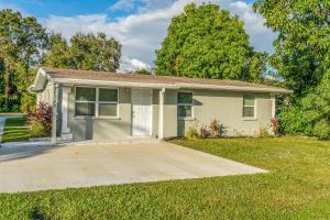 a small white house with a driveway at Noel Real Estate in Naples