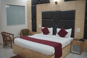 a bedroom with a large bed with red pillows at Bell Mount Mussoorie Hill view Hotel in Mussoorie