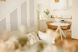 a living room with a table and a kitchen at Casa do Mar - Casas do Levante in Olhão