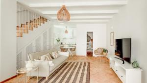 a living room with a couch and a tv at Casa do Mar - Casas do Levante in Olhão