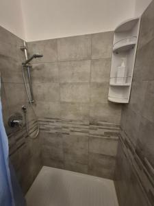 a bathroom with a shower with a glass door at Casa vacanza Monoboito in Quartu SantʼElena