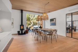 a dining room with a table and chairs and a fireplace at Feriehus 1161 in Ringkøbing