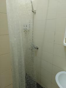 a shower with a glass door with a sink at Atom hostel for men in Astana