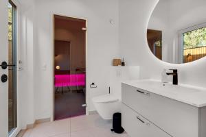 a white bathroom with a toilet and a mirror at Feriehus 1161 in Ringkøbing +32 photos