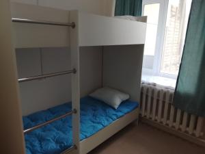 a bunk bed in a room with a window at Atom hostel for men in Astana