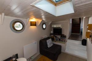 a small living room with a chair and a window at Le grand large - Péniche Octopus in Metz