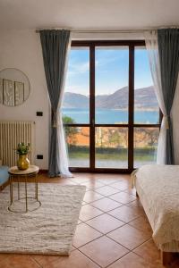 a bedroom with a bed and a large window at Residenz Ai Ronchi in Germignaga