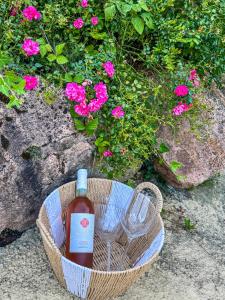 a bottle of wine in a basket with a glass at Residenz Ai Ronchi in Germignaga +32 photos