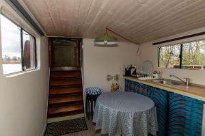 a kitchen with a table and a sink in a trailer at Le grand large - Péniche Octopus in Metz