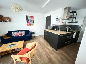 a kitchen and living room with a blue couch at À La Cour de Ribeauvillé avec garage in Ribeauvillé