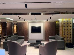 a waiting room with couches and a tv and a table at Samsun Park Hotel in Samsun
