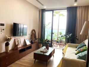 a living room with a couch and a tv at Caracole homestay - 2BR with cozy balcony garden in Kim Quan