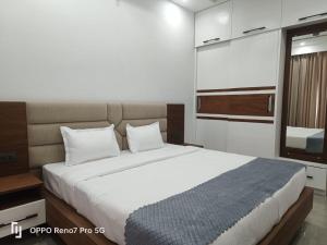 a bedroom with a large white bed and a window at THE BBN Hotel in Solan