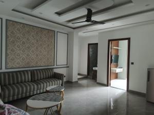 a living room with a couch and a ceiling fan at THE BBN Hotel in Solan