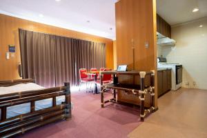 a room with a kitchen with a table and chairs at Royal Hotel in Yomitan