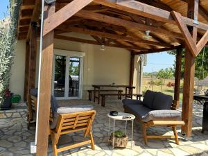 an outdoor patio with chairs and a table with a table at Kuća za odmor - Snowwhite in Smoković