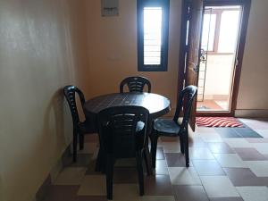 a dining room table with chairs and a table and a door at coorg mantion homestay in Madikeri