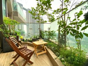a balcony with two chairs and a table on a building at Caracole homestay - 2BR with cozy balcony garden in Kim Quan