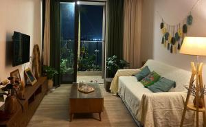 a living room with a couch and a table and a window at Caracole homestay - 2BR with cozy balcony garden in Kim Quan +12 photos
