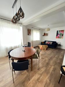 a living room with a wooden table and chairs at À La Cour de Ribeauvillé avec garage in Ribeauvillé +6 photos
