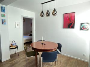 a dining room with a wooden table and chairs at À La Cour de Ribeauvillé avec garage in Ribeauvillé