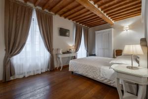 a bedroom with a bed and a table with a lamp at Le Camere Del Ceccottino in Pitigliano