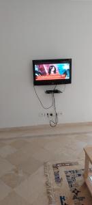 a flat screen tv hanging on a white wall at Appartement superbe à Hammamet in Nabeul