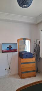 a bedroom with a tv and a dresser with a mirror at Appartement superbe à Hammamet in Nabeul