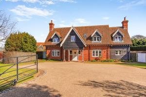 a large brick house with a gate in front of it at 5 Bed in Walberswick oc-hlwal in Walberswick