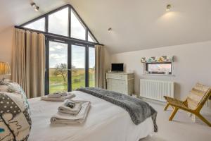 a bedroom with a bed and a window and a chair at 3 Bed in Dunwich oc-slh in Dunwich