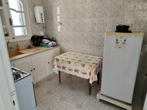 a small kitchen with a table and a refrigerator at Studio ANDALOUS in Mahdia +7 photos