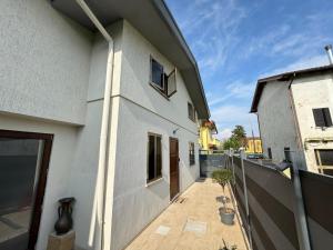 a white building with a balcony with a fence at Vila Bella in Lugugnana