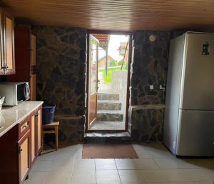 a kitchen with a refrigerator and a stone wall at котедж Квітуча Гора in Yablunytsya +8 photos