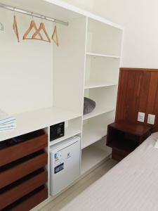 a bedroom with white cabinets and a bed at Pousada Casa Zoe Búzios in Búzios