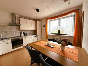 a kitchen with a wooden table and a dining room at Ferienwohnung Weinbergblick in Oberrohrendorf
