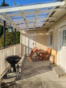 a patio with a grill and a wooden pergola at Pikkurinki 28 As 2, 62300 Härmä Kauhava in Alahärmä