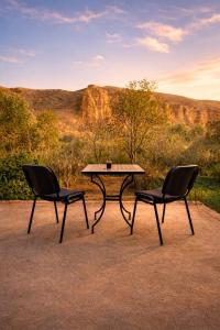 two chairs and a table in front of a mountain at Chez BABAYO BY DADES in Zaouïet Sidi Daoud