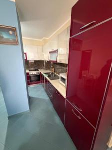 a kitchen with red cabinets and a red refrigerator at Aldi APARTMENTS in Lezhë +2 photos