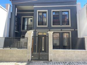 a house with a black gate in front of it at Liams Cozy Villa in Korçë
