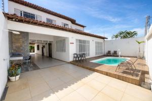 a patio with a swimming pool and a house at Star HOUSE beach in Aracaju