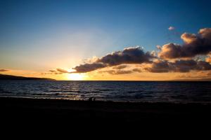 a sunset on the beach with the sun setting at The Original Donnini Apartment in Ayr
