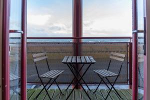 two chairs and a table on a balcony at The Original Donnini Apartment in Ayr