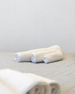 two rolls of white towels sitting on a tile floor at Casa Rosa - hidden Garden with lake view in Fiumelatte