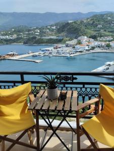 a table and chairs on a balcony with a harbor at Kalli's View in Evdilos