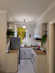 a kitchen with white cabinets and a refrigerator at Kalli's View in Evdilos