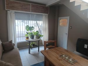 a living room with a table and a window at La casa de Napoli in Trelew