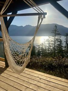 a hammock on a deck with a view of the water at Gorgeous Ocean and Mountain View King Suite in Bowen Island