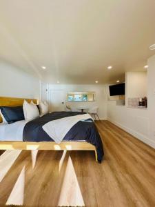 a bedroom with a large bed and a flat screen tv at Gorgeous Ocean and Mountain View King Suite in Bowen Island
